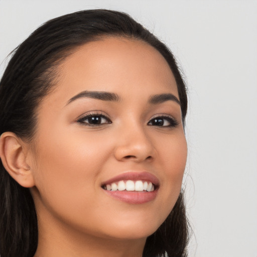 Joyful latino young-adult female with long  brown hair and brown eyes