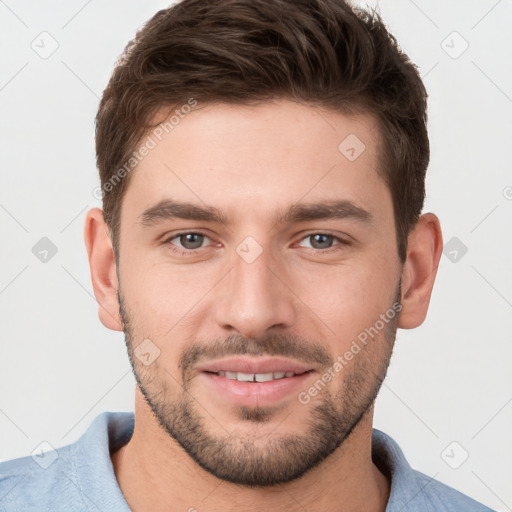 Joyful white young-adult male with short  brown hair and grey eyes