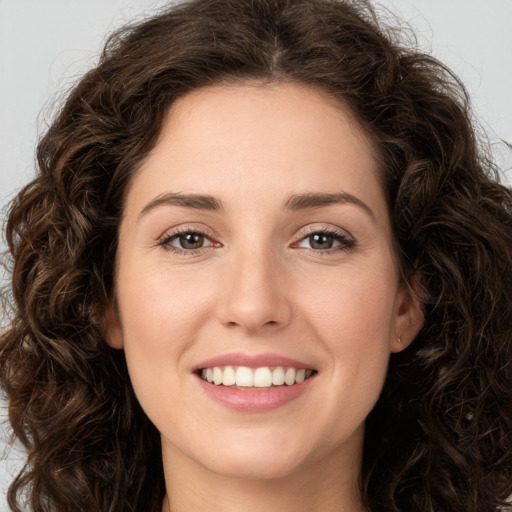 Joyful white young-adult female with long  brown hair and green eyes