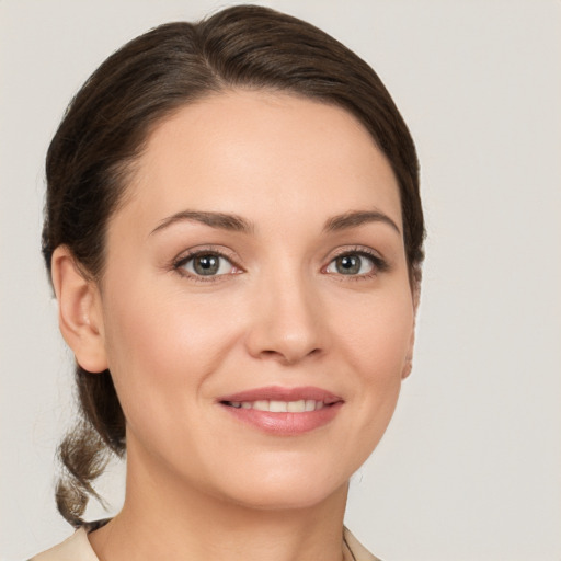 Joyful white young-adult female with medium  brown hair and grey eyes