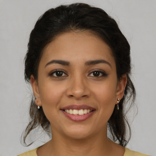 Joyful latino young-adult female with medium  brown hair and brown eyes