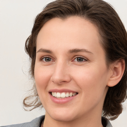 Joyful white young-adult female with medium  brown hair and grey eyes