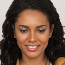 Joyful black young-adult female with long  brown hair and brown eyes