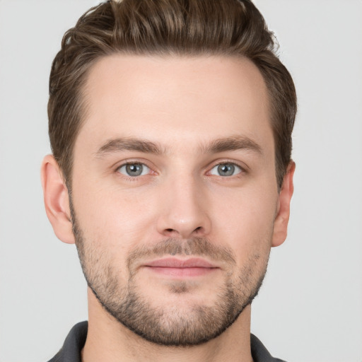 Joyful white young-adult male with short  brown hair and grey eyes