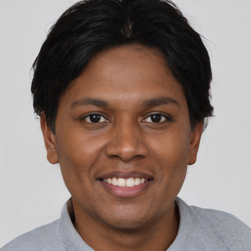 Joyful black young-adult female with short  black hair and brown eyes