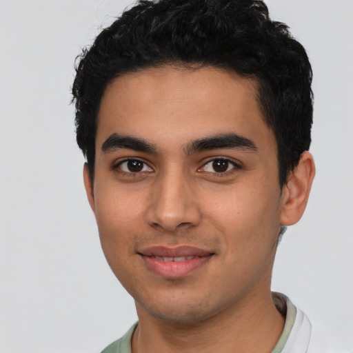 Joyful latino young-adult male with short  black hair and brown eyes