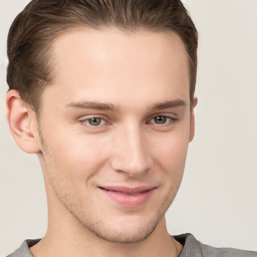 Joyful white young-adult male with short  brown hair and grey eyes