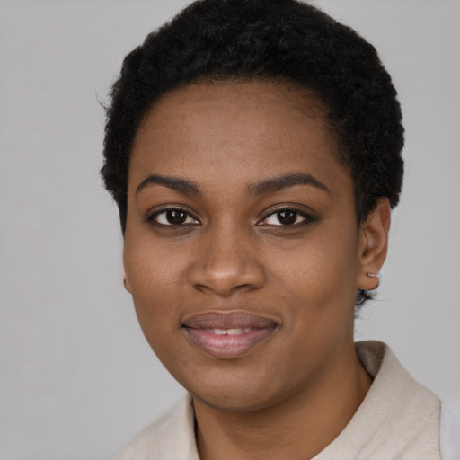 Joyful black young-adult female with short  black hair and brown eyes