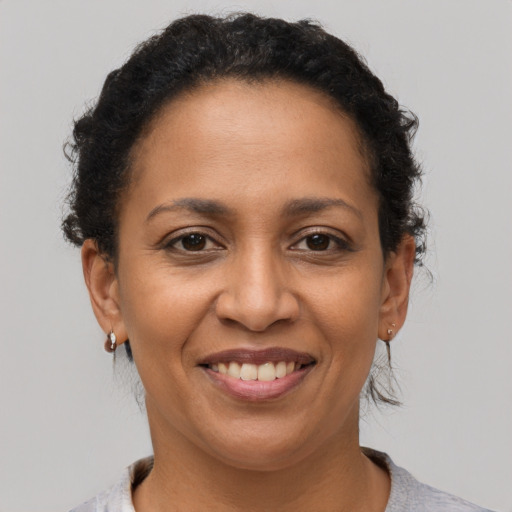 Joyful latino adult female with short  brown hair and brown eyes
