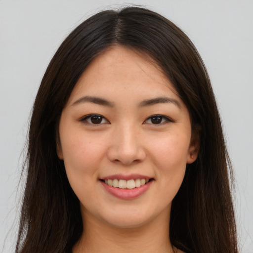 Joyful asian young-adult female with long  brown hair and brown eyes
