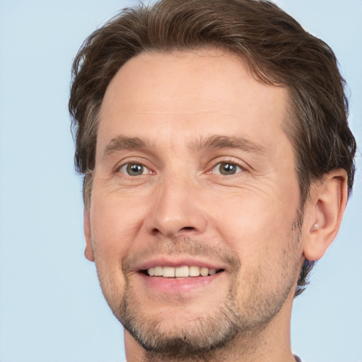 Joyful white adult male with short  brown hair and brown eyes