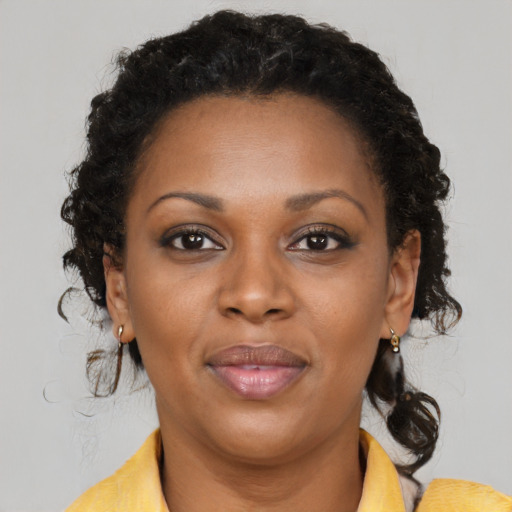 Joyful black young-adult female with medium  brown hair and brown eyes