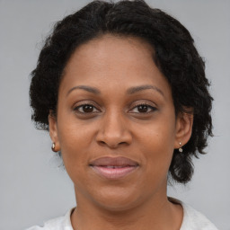 Joyful black adult female with short  brown hair and brown eyes