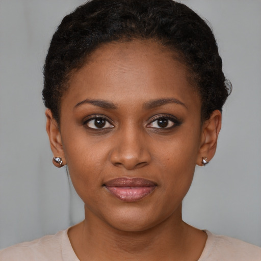 Joyful black young-adult female with short  brown hair and brown eyes
