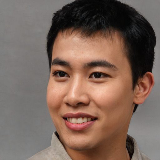 Joyful asian young-adult male with short  black hair and brown eyes