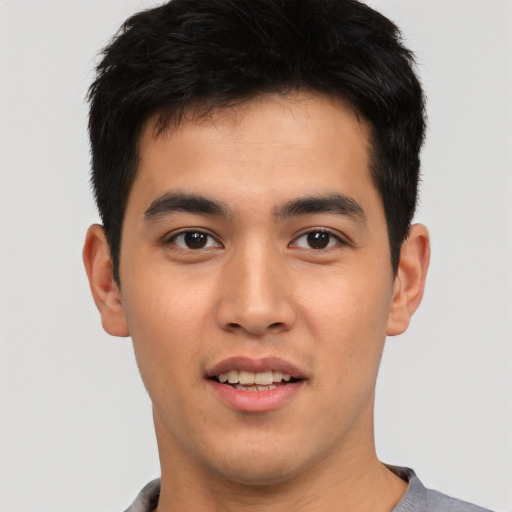 Joyful asian young-adult male with short  brown hair and brown eyes