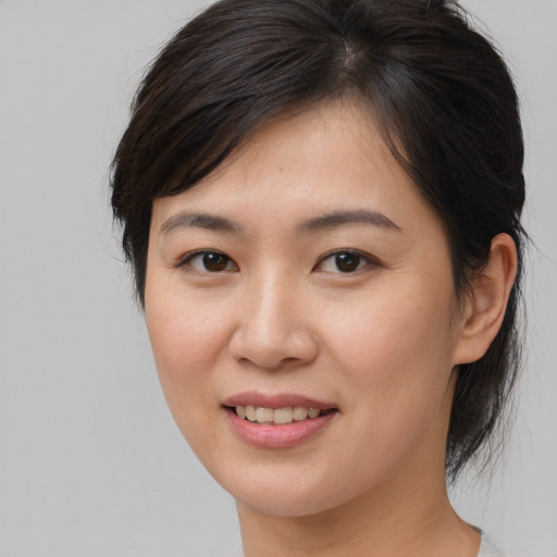 Joyful asian young-adult female with medium  brown hair and brown eyes
