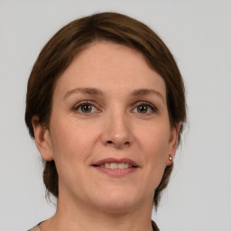 Joyful white adult female with medium  brown hair and grey eyes