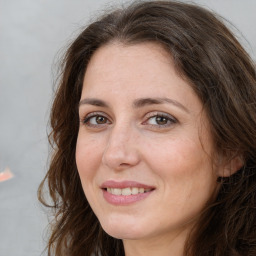 Joyful white adult female with long  brown hair and brown eyes