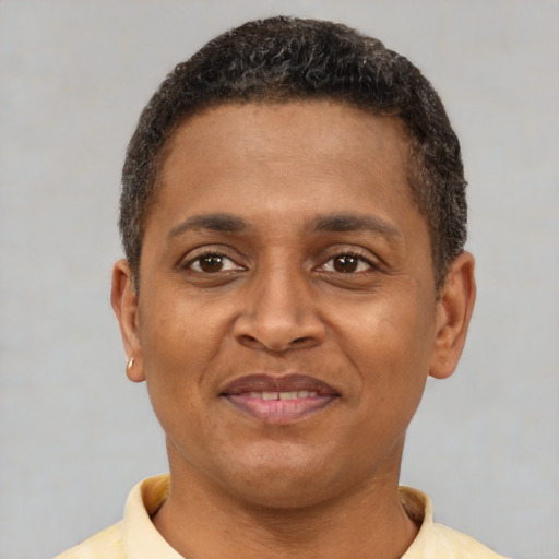 Joyful latino young-adult male with short  brown hair and brown eyes