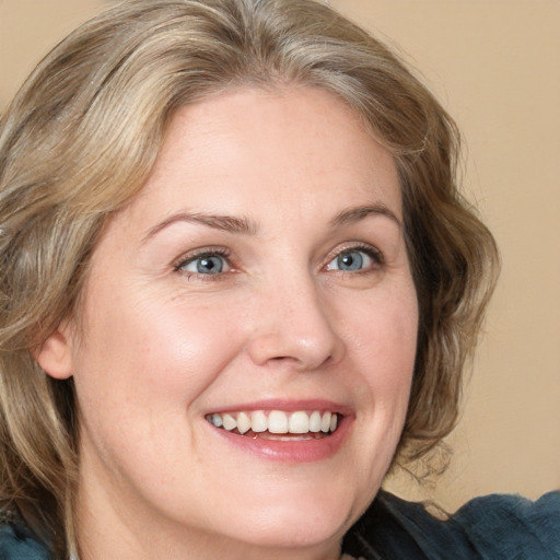 Joyful white adult female with medium  brown hair and blue eyes