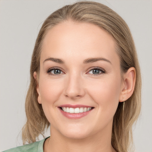 Joyful white young-adult female with medium  brown hair and green eyes