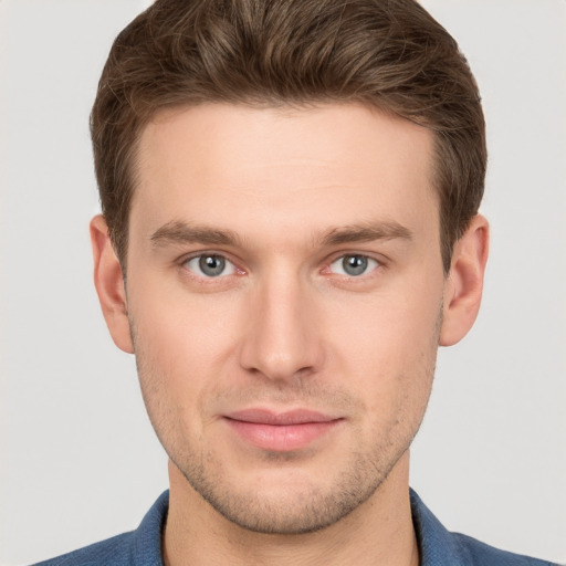 Joyful white young-adult male with short  brown hair and grey eyes