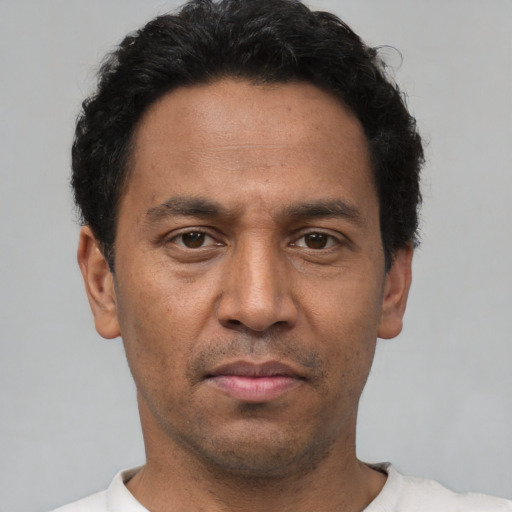 Neutral latino adult male with short  black hair and brown eyes