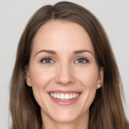 Joyful white young-adult female with long  brown hair and grey eyes