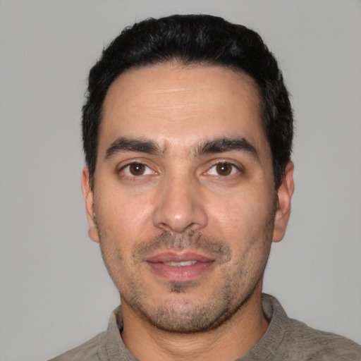 Joyful white young-adult male with short  black hair and brown eyes