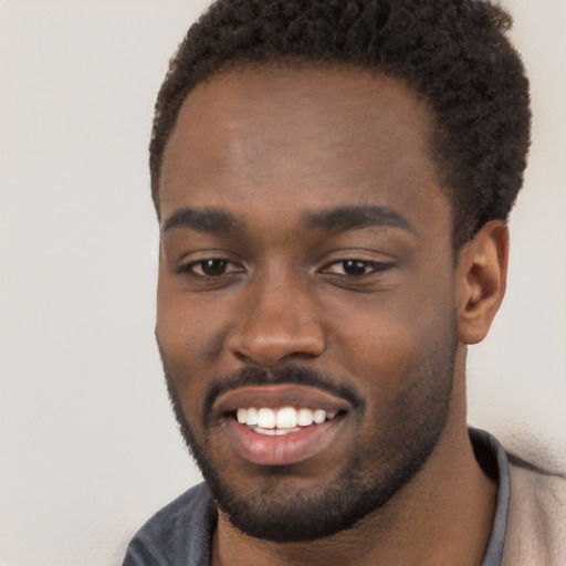 Joyful black young-adult male with short  brown hair and brown eyes