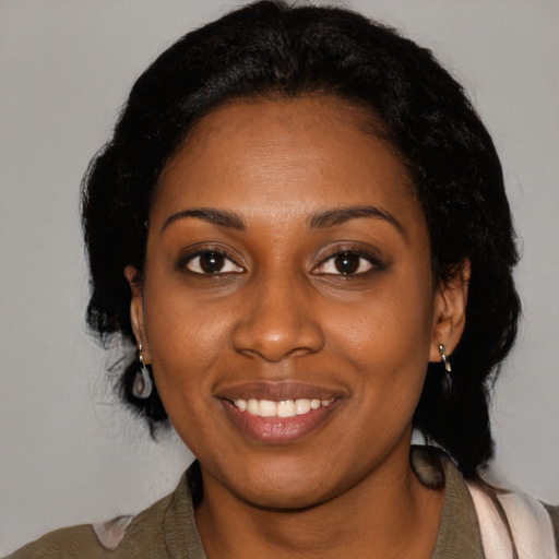 Joyful black young-adult female with medium  black hair and brown eyes