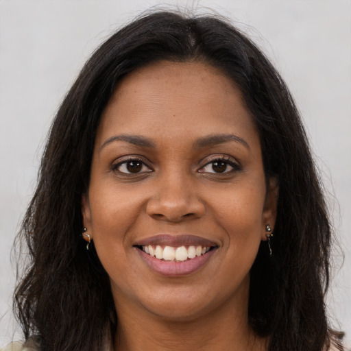 Joyful black young-adult female with long  brown hair and brown eyes