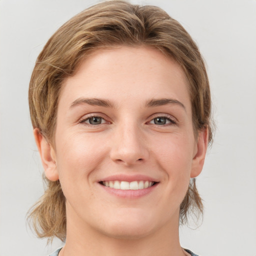 Joyful white young-adult female with medium  brown hair and grey eyes