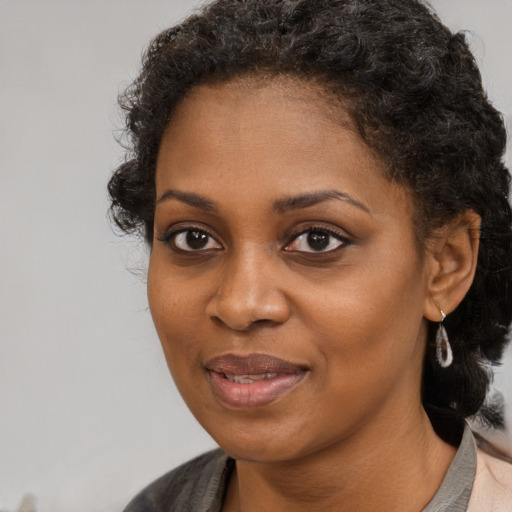 Joyful black young-adult female with medium  brown hair and brown eyes