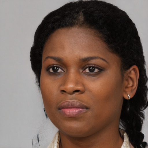 Joyful black young-adult female with long  black hair and brown eyes