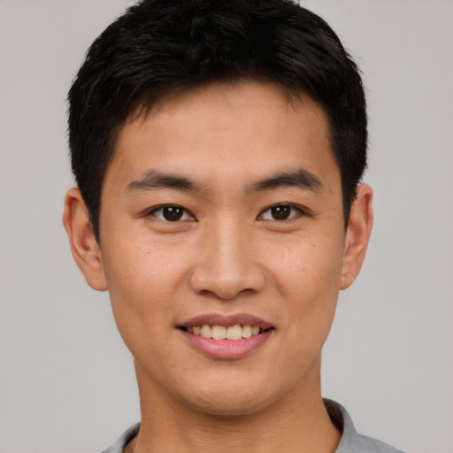 Joyful asian young-adult male with short  black hair and brown eyes