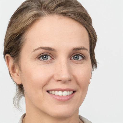 Joyful white young-adult female with medium  brown hair and grey eyes