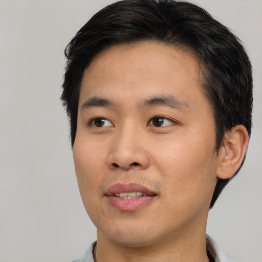 Joyful asian young-adult male with short  brown hair and brown eyes