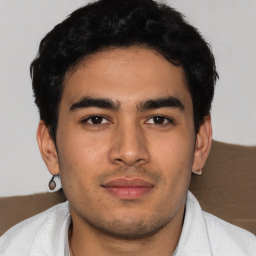 Joyful latino young-adult male with short  black hair and brown eyes
