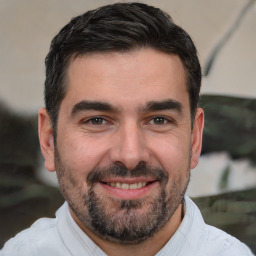 Joyful white adult male with short  black hair and brown eyes