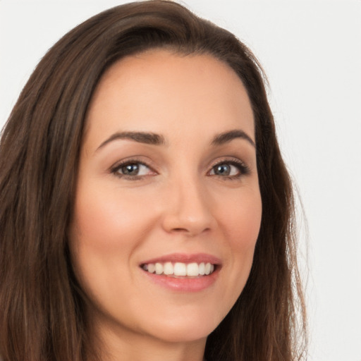 Joyful white young-adult female with long  brown hair and brown eyes