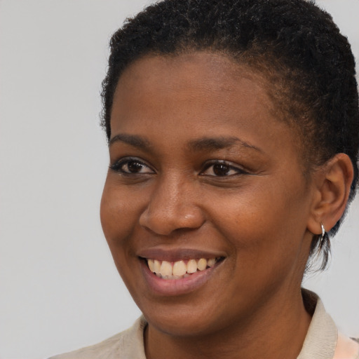 Joyful black young-adult female with short  brown hair and brown eyes
