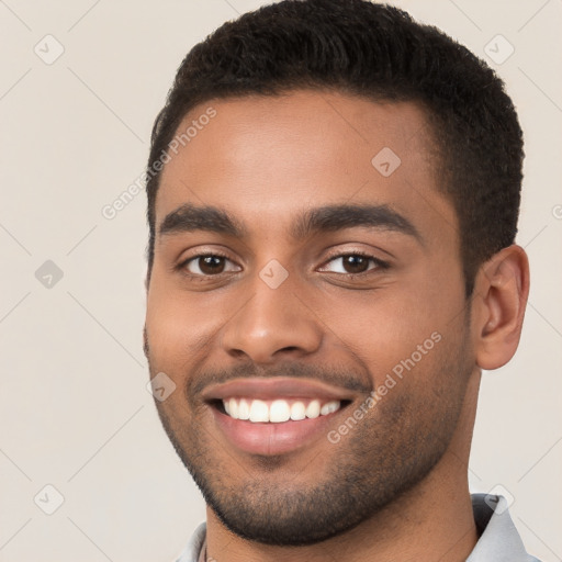 Joyful black young-adult male with short  brown hair and brown eyes