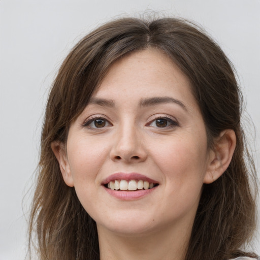 Joyful white young-adult female with long  brown hair and grey eyes