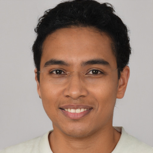 Joyful latino young-adult male with short  black hair and brown eyes