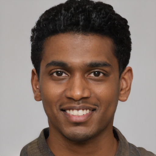 Joyful black young-adult male with short  black hair and brown eyes