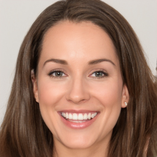 Joyful white young-adult female with long  brown hair and brown eyes