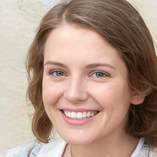 Joyful white young-adult female with medium  brown hair and blue eyes