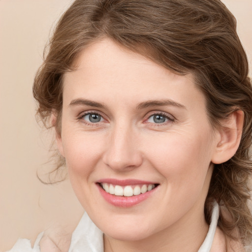 Joyful white young-adult female with medium  brown hair and green eyes